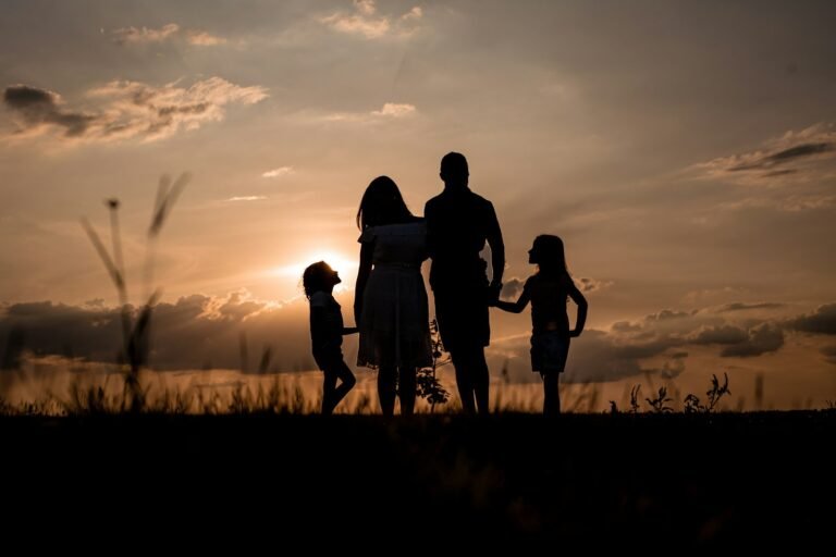 Familia reunida em um campo ao por do sol