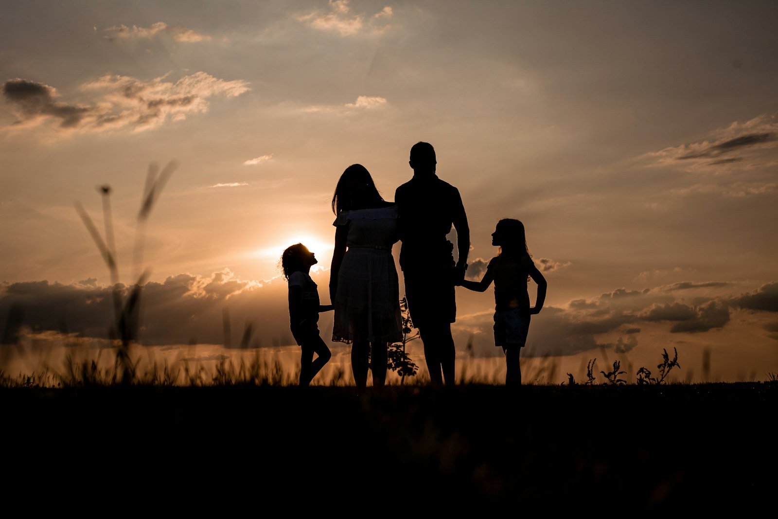 Familia reunida em um campo ao por do sol
