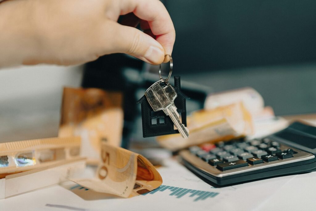 Pessoa segurando chave de casa diante de uma calculadora