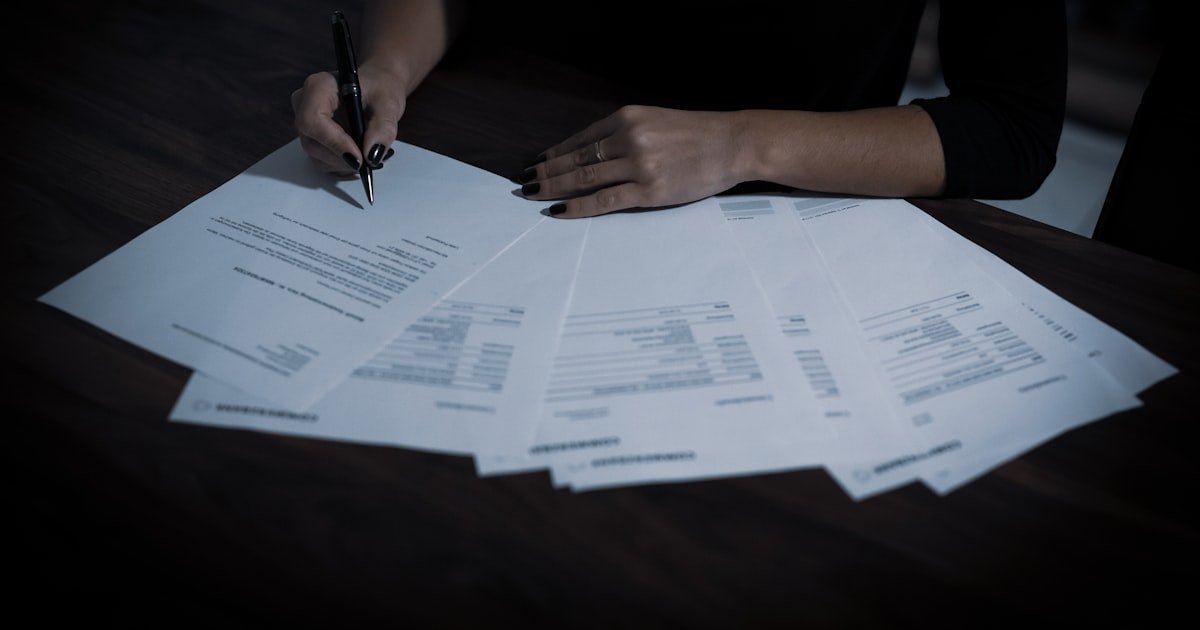 Mulher assinando documento com caneta esferográfica